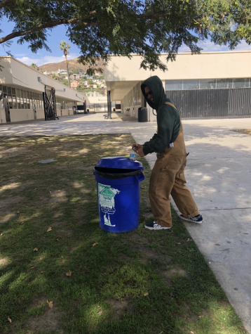 Sophomore Simon Brown doing his part by recycling his water bottle. Photo by: Jessica Johnson