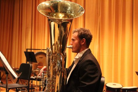VHS Wind Ensemble Honors tubist senior Kirk Mellring warms up before the concert. Photo by: Lola Bobrow