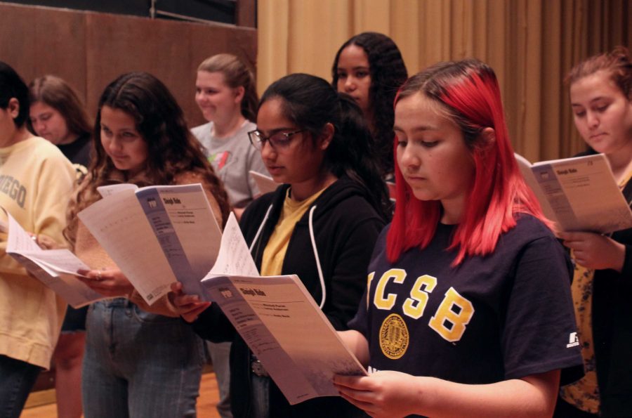 From right to left, freshmen Sinthia Cardenas, Arkiran Khiara, and Vanessa Mercado practicing the alto part of Holiday Film Festival, arranged by Alan Billingsley. Photo by: Juliana Jacobson
