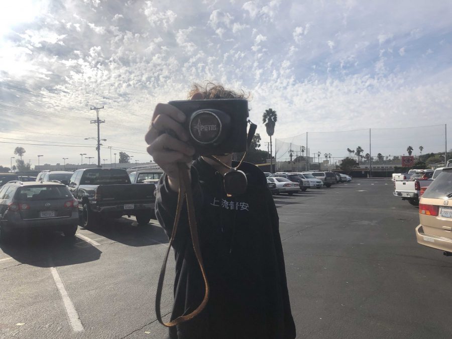 Hibbler holds the camera that he plans to take the unfiltered photos on in front of his face to portray that he wants to stay as anonymous as possible. Photo by: Doug Sandford