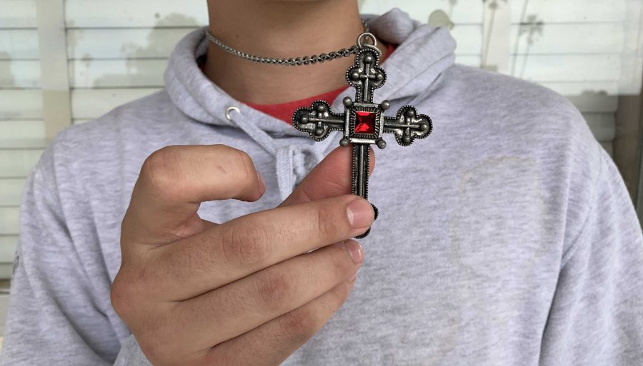 Sophomore+Lucca+Camus+shows+off+his+cross+that+he+wears+daily.+Its+cool+and+gothic%2C+but+keeps+me+protected+%5Bfrom+ghosts%5D+at+the+same+time.+Photo+by%3A+Katie+Medina