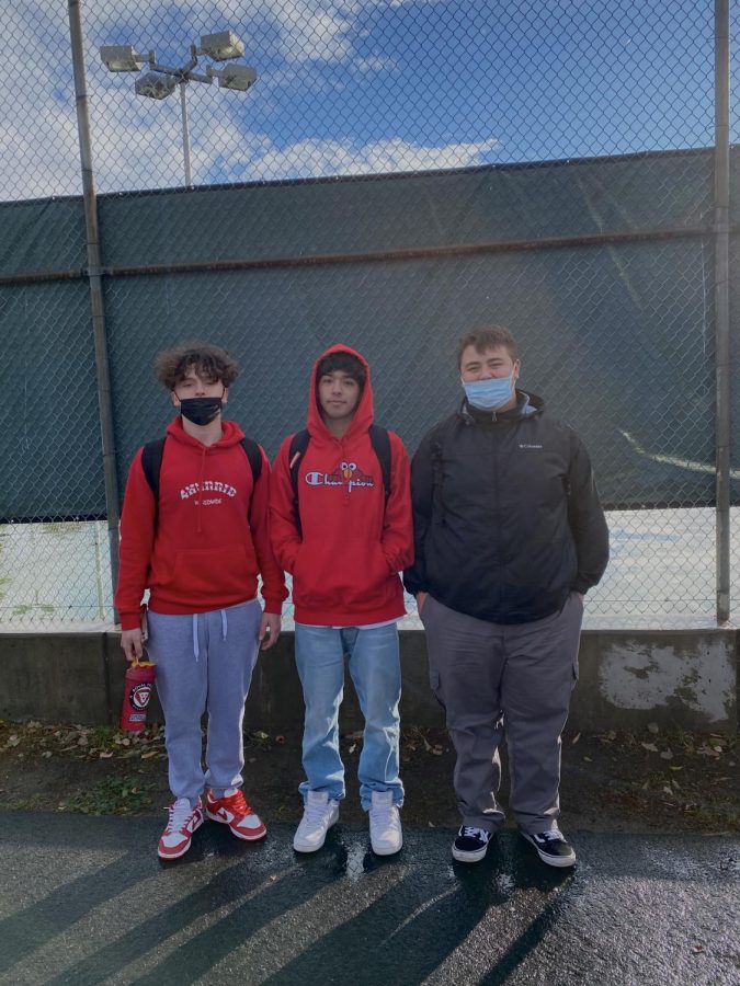 Juniors and sophomores, left to right: Dylan Garcia (11th), Joey Reynoso (10th), and Jacob Frites (11th). Garcia is wearing a red hoodie, with light grey sweatpants and red with white Nikes. Reynoso is wearing a red champion hoodie with Elmo peaking on top of the lettering. He matched it with light blue jeans and white shoes. Frites is wearing a black Columbia jacket with dark grey pants and black vans. Photo By: Gisselle Garcia