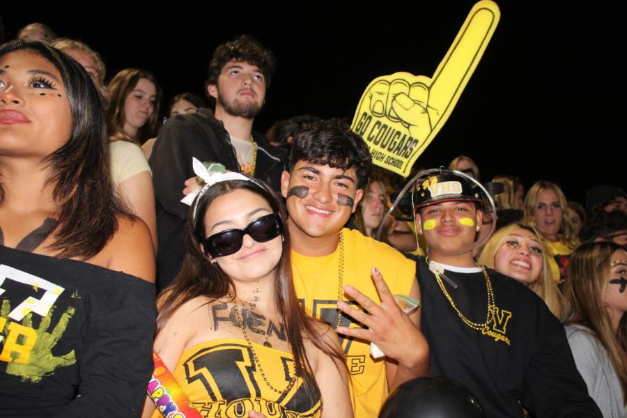 Vivian Ruvalcaba ‘23 (left) and Isaac Lopez ‘23 (right) during the rivalry game. Ruvalcaba had “Fuena” on her chest which stands for “f*** Buena.” Lopez held a bag of flour, which is a celebratory tradition after scoring touchdowns during the game. The student section threw flour into the air after each VHS score. Lopez said, “We did really well supporting our team. We were there for the team the whole game. We were louder than Buena’s student section for sure.” Photo by: Ella Montano
