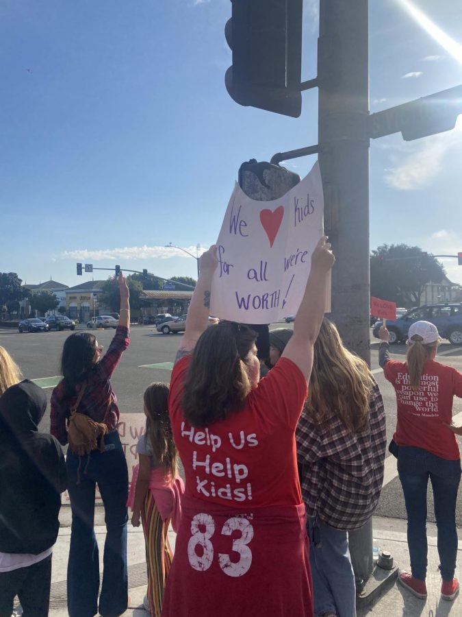 English teacher Elizabeth Mainz (lower-center) holds a sign that reads, We love kids for all were worth! at an Oct. 10 VUEA protest. Photo by: Brody Daw