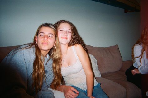 Mia Sinclair 24 and Liviya Nascimento 24 , left to right, sit together at a birthday party. Photo by: Ava Mohror
