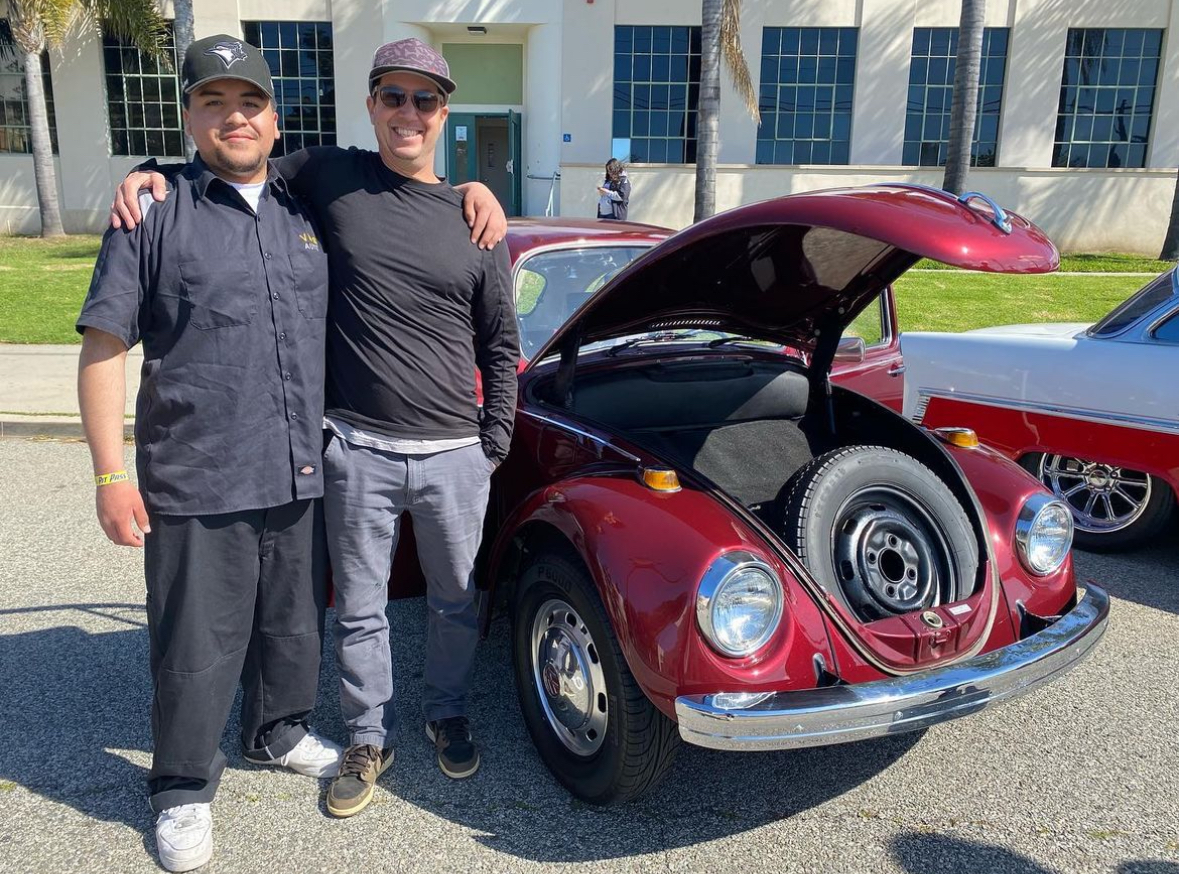 VHS English teacher Erik Votruba (right) brought his Type One Volkswagen Beetle. Vortuba said, “I can’t take a ton of credit for it, it belonged to my wifes uncle. He bought it brand new in Santa Barbara in 1969.” He hasnt done much to it since being given the car. Before he got his hands on it, the car got a new paint job and had been  reupholstered. Photo by:@venturahscougars 
