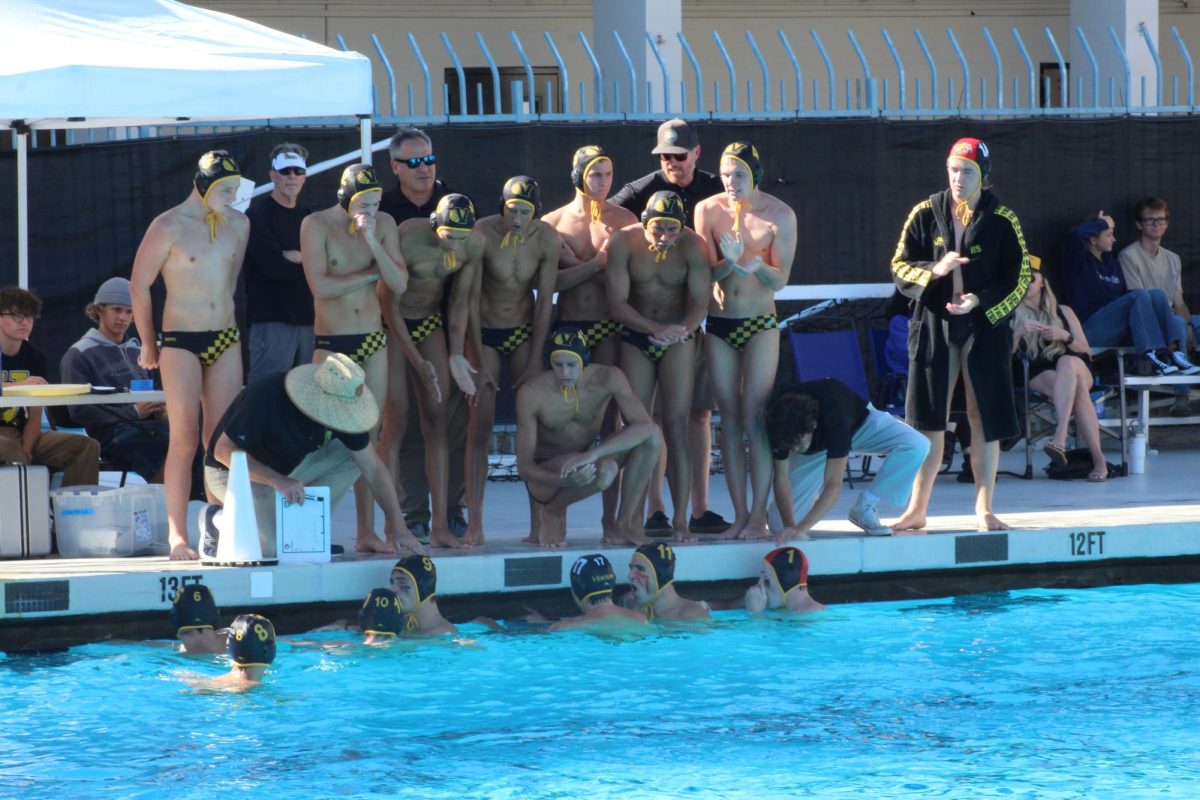 The VHS water polo team strategize during a time out. Photo by: Natalie Di Silvestri
